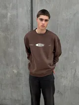 Buzo marrón de algodón con cuello redondo, puños y cintura acanalados. Estampa frontal con el logo de la marca en color blanco.