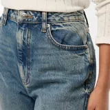 Pantalón de jean celeste, de corte recto y tiro alto, con lavado gastado y dobladillo ancho.