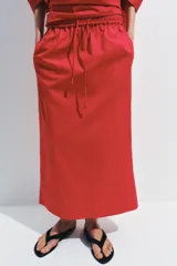 Falda midi de tiro medio confeccionada en algodón, con cintura elástica ajustable mediante cordones y bajo recto.