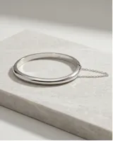 Esclava rígida de plata 925 con diseño minimalista y cadena de seguridad incorporada.