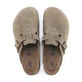 Zueco Birkenstock modelo Boston con plantilla blanda, confeccionado en cuero aceitado color marrón. Presenta una tira ajustable con hebilla metálica y suela de corcho y goma.