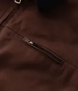 Campera masculina modelo trucker confeccionada en sarga de algodón. Presenta cuello de terciopelo en contraste, cierre frontal con cremallera, manga larga y bolsillo con cremallera en el pecho.