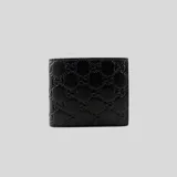 Billetera bifold de cuero negro con diseño grabado del monograma GG de Gucci en relieve.