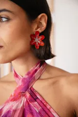 Aro en forma de flor de color rojo con diseño central de estrella con glitter plateado.