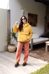 Buzo amarillo acolchado con capucha y cierre parcial con botones a presión.