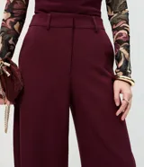 Pantalón de sastrería color bordó, con modelaje barrel, cintura estructurada, pasadores para cinturón y piernas amplias con ruedo levemente afinado.