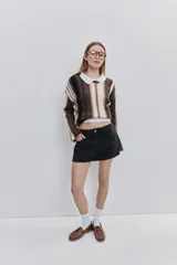 Minifalda de jean negra con silueta recta, tiro medio y bolsillos funcionales delanteros y traseros.