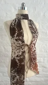 Top halter con estampado animal print de vaca, con tiras finas que se atan en la nuca y en la espalda.