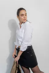 Falda corta de corte recto confeccionada en lentejuelas negras, con cierre posterior.