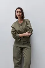 Pantalón jean de tiro alto con calce straight y pierna recta, confeccionado en denim de aspecto limpio. Cuenta con cinco bolsillos, cierre frontal con botón y presillas para cinturón.