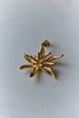 Collar con dije de acero quirúrgico en forma de flor de lirio, montado sobre un tiento de cuero encerado largo.