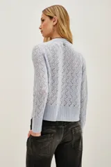 Sweater de punto calado con diseño de ondas, cuello redondo y mangas largas con puños acanalados.