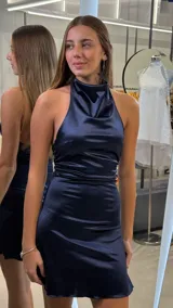 Vestido corto de satén color azul marino, sin mangas, con cuello halter drapeado y diseño ajustado.