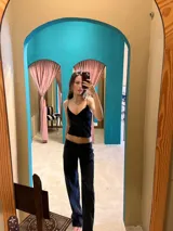 Top tipo musculosa de color negro confeccionado en terciopelo con microtul, con tirantes finos elásticos y escote en V. Presenta espalda elástica y doble tela en la zona del busto para evitar transparencias.