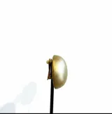 Caravanas de diseño minimalista con forma de media esfera en color dorado mate. Cuentan con un acabado texturizado y cierre de clip.
