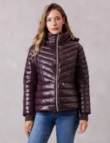 Campera puffer de acabado satinado en color marrón oscuro. Presenta un diseño capitoneado con líneas en V, cierre frontal metálico, capucha fija y puños internos de tejido elastizado con abertura para el pulgar. Incluye bolsillos laterales con cierre invisible y logo metálico en la manga.