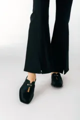 Zuecos de cuero color bordó con punta cuadrada, detalle de abertura en el empeine y aplique metálico dorado.