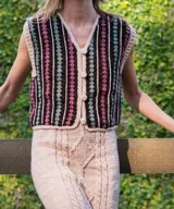 Chaleco tejido a mano en crochet de lana merino, con diseño de rayas verticales en marrón, fucsia y verde, escote en V y cierre frontal con botones forrados.