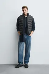 Chaleco acolchado de hombre color negro, con diseño puffer, cuello alto y cierre frontal con cremallera.
