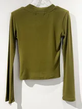 Remera de manga larga color negro, con escote en V y mangas acampanadas tipo Oxford. Confeccionada en tejido de algodón elastizado, con un diseño entallado al cuerpo.
