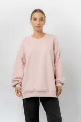 Buzo oversize de cuello redondo, confeccionado en algodón suave con interior frizado. Presenta un diseño de líneas simples, corte relajado y mangas largas con puños ajustados.