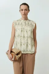 Blusa sin mangas color crema con estampado abstracto en verde oliva y cuello con punto smock.