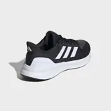 Championes de running Adidas Ultrarun 5, color negro con tres franjas blancas características en el lateral. Presentan una suela gruesa blanca con textura y detalles en negro en la parte inferior.