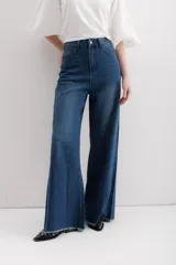 Pantalón de jean de corte ancho, color azul oscuro, con cintura alta y terminación desflecada.