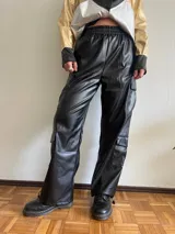 Pantalón cargo negro de cuero sintético, corte holgado, cintura elastizada y bolsillos laterales con solapa.