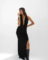 Vestido largo negro de corte ajustado, con escote profundo en V y espalda descubierta. Presenta un tajo lateral en la falda y un detalle de textura brillante en el borde del escote.