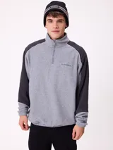 Gorro tipo beanie de punto en color gris, con franjas horizontales en verde y blanco, y logo de la marca Rusty en el frente.