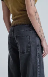 Pantalón de denim negro lavado, estilo wide leg, de cinco bolsillos y tiro alto.