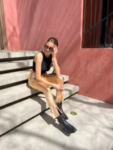 Pantalón negro de tiro alto, corte ajustado y confeccionado en gabardina elastizada con acabado metalizado.