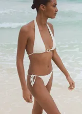 Braga de bikini blanca con textura, corte cheeky, forro interior y cierre de lazos laterales.