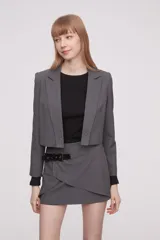 Blazer corto gris con cuello solapa y cierre con dos botones.