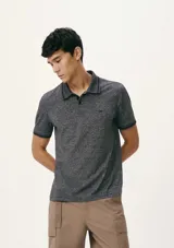 Chomba verde militar melange de manga corta, con cuello polo y cierre frontal de botones, con sutil estampado y ribetes en contraste en cuello y puños.