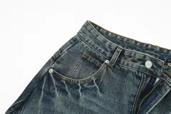 Pantalón de jean de corte extremadamente ancho (hiper baggy) con lavado oscuro y efecto desgastado. Presenta costuras marcadas en el frente y bolsillos delanteros y traseros.