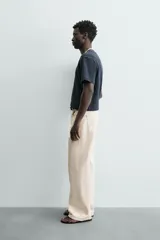 Camiseta de manga corta y cuello redondo, color azul marino, con ribete de contraste en color crema alrededor del cuello.