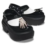 Zuecos Crocs Stomp de plataforma alta, color negro con detalles en blanco, con correa trasera ajustable y dijes Jibbitz inspirados en la serie Wednesday.