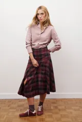 Falda midi de corte irregular con diseño a cuadros en tonos marrones, negros y beige. Presenta una silueta acampanada con caída fluida.