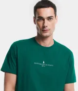 Remera de corte comfort color verde, con cuello redondo y manga corta. Presenta un pequeño estampado minimalista en el centro del pecho con la inscripción 'Nautique des Regates'.