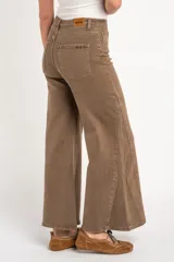 Jean de corte flare y tiro alto, color marrón lavado con costuras decorativas verticales en las piernas y diseño de cinco bolsillos.