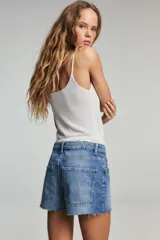 Shorts de jean de tiro bajo con diseño de cinco bolsillos, cintura con trabillas y cierre frontal con cremallera y botón metálico.