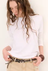 Remera blanca de manga larga con cuello redondo y diseño bordado en el pecho.