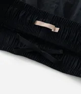 Short deportivo modelo runner de Ashua, confeccionado en poliamida con tecnología dry de secado rápido. Presenta un diseño holgado con cintura elástica, bajos redondeados con vivos laterales en contraste y detalle de lettering en el ruedo.
