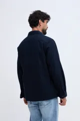 Sobrecamisa azul marino confeccionada en mezcla de lino y algodón, con cuello clásico, cierre frontal de botones, bolsillos aplicados en el pecho y bolsillos inferiores.