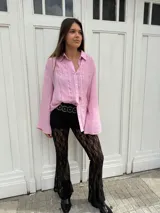 Pantalón de encaje negro con corte acampanado y cintura alta.