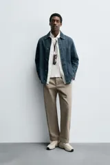 Pantalón de corte recto confeccionado en tejido de algodón con estructura twill, con bolsillos frontales y bolsillos traseros de vivo con botón.