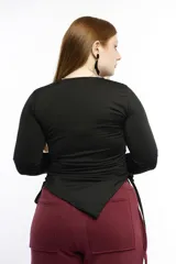 Top de manga larga color negro, confeccionado en jersey elástico. Presenta un diseño asimétrico con jaretas laterales regulables que permiten ajustar el largo y el volumen, y aberturas para los pulgares en los puños.