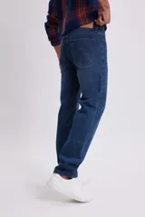 Pantalon de jean de corte clasico en color azul oscuro, con cierre de boton y cremallera, y bolsillos laterales y traseros.